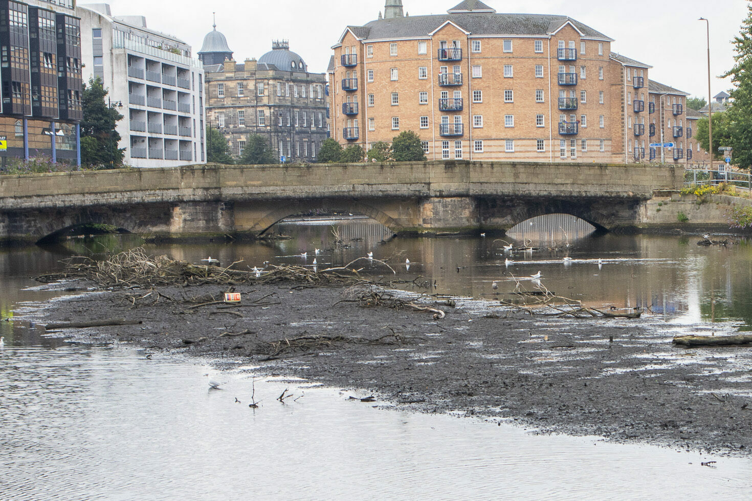 Sandport Bridge, 2023. The water level in Water of Leith has risen considerably, with debris floating on the surface. 