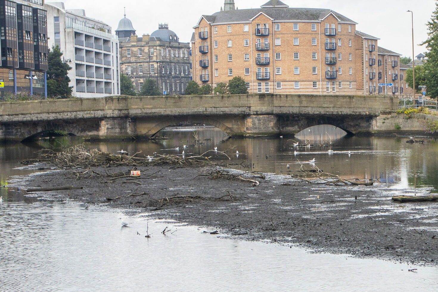 Sandport Bridge, 2023. The water level in Water of Leith has risen considerably, with debris floating on the surface.